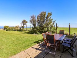 An outdoor dining area with a table and chairs at Voebroch in Lythe