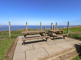 An outdoor seating area with tables and a view of the sea at Voebroch in Lythe