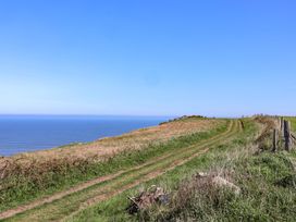 A pathway leading to the ocean with a fence at Voebroch in Lythe
