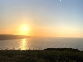 A sunset over the ocean with grass in the foreground at Voebroch in Lythe