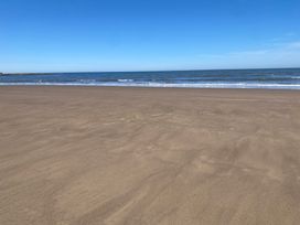 A beach with sand and ocean waves at Voebroch in Lythe