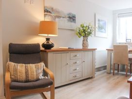 A living room with a chair, lamp, and cabinet at Simples in Dartmouth