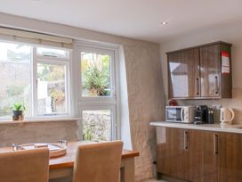 A kitchen with a table and chairs, kitchen appliances at Simples in Dartmouth