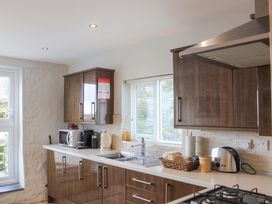 A kitchen with cabinets, appliances, and window at Simples in Dartmouth