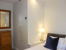 A bedroom with a chest of drawers and a wall cabinet at Simples in Dartmouth