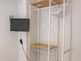 A coat rack with a shelf and television at Simples Dartmouth