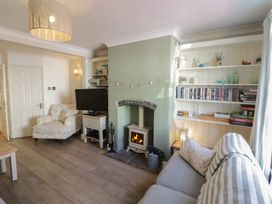 A living room with a fireplace and bookshelves at Heath Cottage in Stratford-Upon-Avon