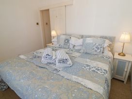 A bedroom with a bed and bedside lamp at Heath Cottage Stratford-Upon-Avon