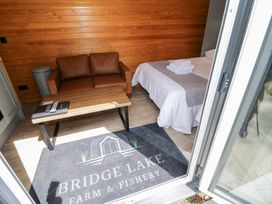 A room with a bed and a sofa at Willow Lodge At Bridge Lake Farm & Fishery Chacombe