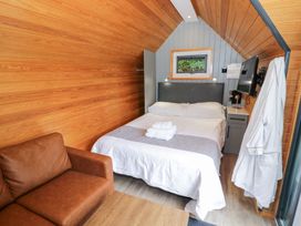 A bedroom with a bed and couch at Willow Lodge At Bridge Lake Farm & Fishery Chacombe