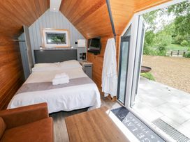 A bedroom with a bed and chairs at Willow Lodge At Bridge Lake Farm & Fishery in Chacombe