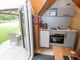 A kitchen area with appliances and a table at Willow Lodge At Bridge Lake Farm & Fishery Chacombe