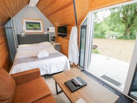 A bedroom with a bed and sofa at Willow Lodge At Bridge Lake Farm & Fishery Chacombe