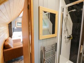 A bathroom with a shower and bedroom view at Willow Lodge At Bridge Lake Farm & Fishery, Chacombe