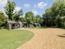 An outdoor area with cabins and gravel path at Willow Lodge At Bridge Lake Farm & Fishery Chacombe