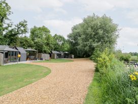 An outdoor area with cabins and a gravel path at Willow Lodge At Bridge Lake Farm & Fishery Chacombe