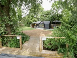 An outdoor area with cabins and a gazebo at Willow Lodge At Bridge Lake Farm & Fishery Chacombe