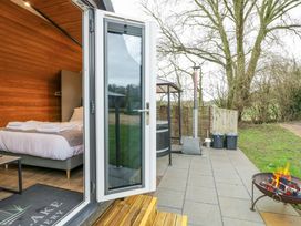 An outdoor area with a bed and fire pit at Willow Lodge At Bridge Lake Farm & Fishery, Chacombe