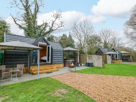 An outdoor area with cabins and seating at Willow Lodge At Bridge Lake Farm & Fishery in Chacombe