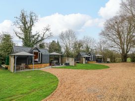 An outdoor area with cabins and a gravel pathway at Willow Lodge At Bridge Lake Farm & Fishery in Chacombe