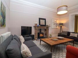 A living room with a fireplace and television at Barnsley House in Teignmouth