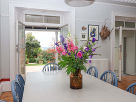 A dining room with a table and flowers in a vase at Barnsley House Teignmouth