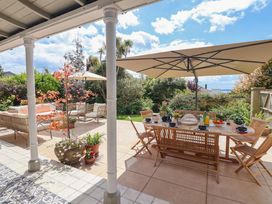 An outdoor patio with a dining table and seating at Barnsley House in Teignmouth
