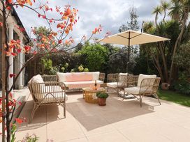 An outdoor seating area with furniture in the garden at Barnsley House Teignmouth