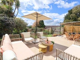 An outdoor seating area with a table and umbrellas at Barnsley House, Teignmouth