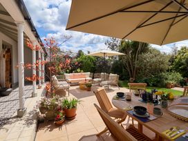 A garden with dining table and umbrellas at Barnsley House Teignmouth