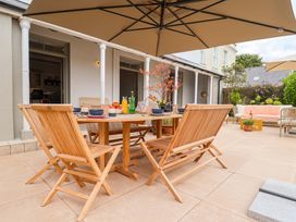 An outdoor dining area with a wooden table and chairs at Barnsley House in Teignmouth
