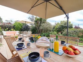 An outdoor dining area with a table set and chair arrangements at Barnsley House in Teignmouth