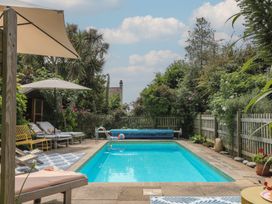 A swimming pool surrounded by deck chairs at Barnsley House in Teignmouth