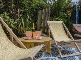 A garden with deck chairs and a table holding champagne at Barnsley House Teignmouth