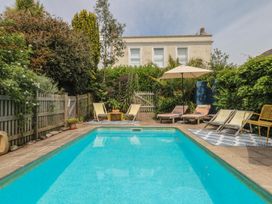 A garden with a swimming pool and sun loungers at Barnsley House in Teignmouth