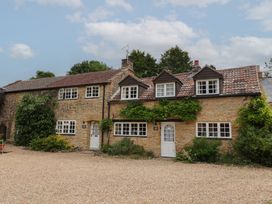 A house with multiple windows and a gravel path at The Old Bakery in South Perrott near Mosterton