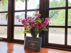 A flower vase and guest book on a window sill at The Old Bakery South Perrott near Mosterton