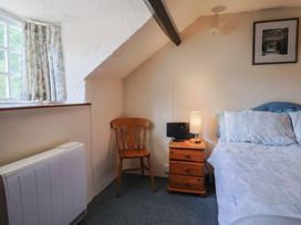 A bedroom with a bed and chair at The Old Bakery in South Perrott near Mosterton