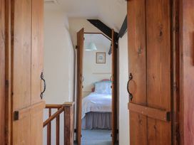 A bedroom entrance with doors and a bed visible at The Old Bakery in South Perrott near Mosterton