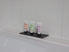 Body wash and conditioner tubes on a shelf in a bathroom at The Old Bakery South Perrott near Mosterton