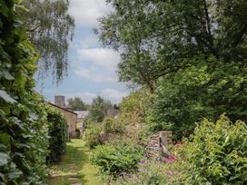 A garden path with flowers and trees at The Old Bakery South Perrott near Mosterton