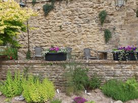 A garden with stone wall, plants, table and chairs at The Old Bakery in South Perrott near Mosterton