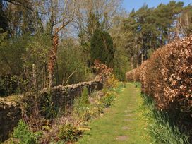 A garden pathway with flowers beside stone walls at Jasmine Cottage South Perrott near Mosterton