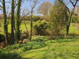 A garden with trees and grass at Jasmine Cottage South Perrott near Mosterton