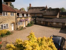 A courtyard with several houses and a car at Jasmine Cottage in South Perrott near Mosterton