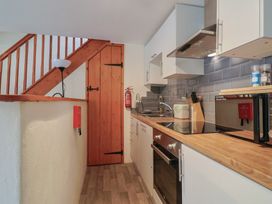 A kitchen with appliances including a stove and microwave at Jasmine Cottage South Perrott near Mosterton