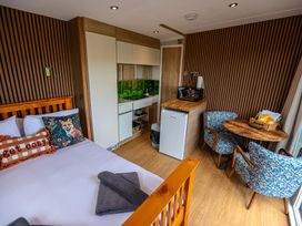 A bedroom with a bed and kitchenette at The Fox Den Nantmel near Rhayader