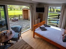 A bedroom with a bed and table at The Fox Den in Nantmel near Rhayader