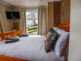 A bedroom with a bed and television at The Fox Den near Rhayader