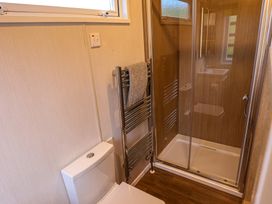 A bathroom with shower, toilet, and towel rail at The Fox Den in Nantmel near Rhayader